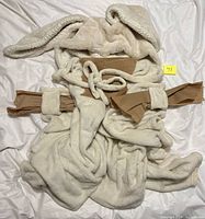 Front view of folded plush hooded rabbit blanket with ears and neck ties visible
