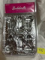 Front of sealed package showing two aluminium pecker cupcake pans