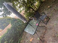 Table, umbrella wrapped in plastic, chair beside table
