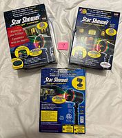 Front view of three Star Shower Laser Light retail boxes