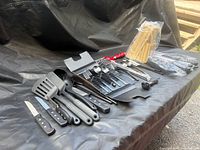 Overview of utensils, knives, flatware tray and bamboo skewers on surface