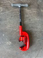 Full view of pipe cutter front side showing red body and handle