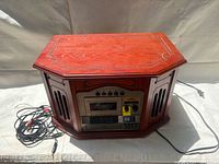 Front angled view of closed wood cabinet unit with attached RCA cables