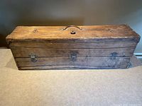 Closed chest front view showing iron handle, hinges, lock plates