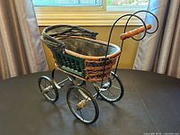Full view of wicker baby carriage on tabletop