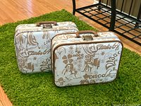 Two matching Studio 64 disco print suitcases closed showing exterior graphics