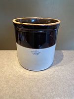 Full view of crock front showing two-tone glaze and crown mark