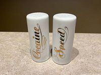 Front view of both shakers showing gold script Cocaine and Speed