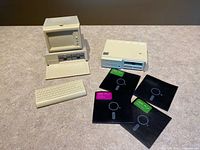 Full set showing monitor/CPU box, keyboard tray, drive holder, four floppy-style coasters