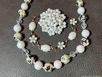 Necklace, bracelet and brooch close-up showing bead and flower details