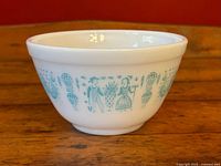 Side view of bowl showing turquoise Butterprint pattern on white milk glass