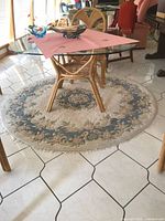 Full view of round rug under glass table showing design and scale