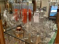 Cabinet shelf with brandy snifters, warmer, decanter, and tall candle holder