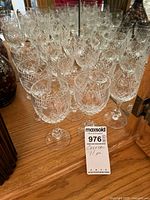 front view of grouped crystal wine glasses on wooden surface
