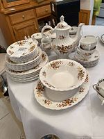 Entire set on table showing teapot, bowls, cups, saucers, stacked plates