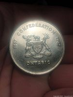 Obverse showing Ontario coat of arms and centennial dates