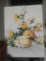 Front view of the oil painting held in hand, showing floral composition, signature, and size context