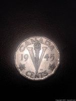 Reverse of 1945 Canadian 5-cent coin showing torch and V design