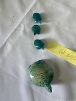 All four stone turtles lined up on cloth