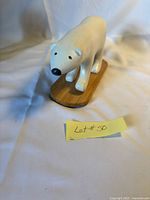 Front view of carved wood polar bear on base