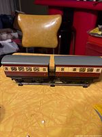 Two Hornby tinplate passenger cars coupled together showing side details