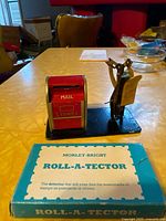 Stamp dispenser and brass scale on base, Roll-A-Tector box in foreground