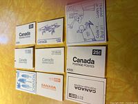 Eight of the nine stamp booklets laid out showing cover designs and denominations