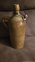 Front view of stoneware jug showing stopper and glaze