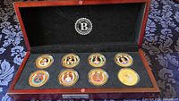 Open presentation case showing eight Princess Diana proof coins in capsules