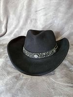 Front angle of black felt western hat showing brim, crown and studded band