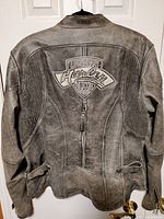 Back view showing embroidered Legendary Harley Garage patch, distressed leather, adjustable side straps