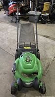Front view of Lawn-Boy mower showing handle, engine cover, and grass bag