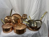 Group shot showing all copper cookware pieces with lids and handles