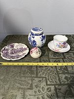 Front view of five china pieces on table with measuring tape