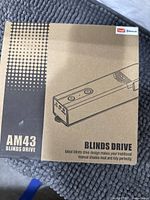 Closed retail box showing AM43 Blinds Drive branding