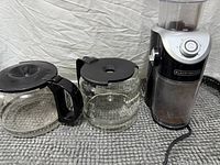 Grinder and both glass carafes side by side showing overall condition