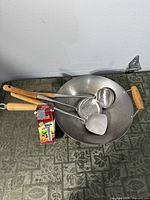 Wok with three utensils and boxed hand press visible