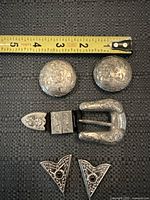 front view showing all seven engraved alpaca pieces with measuring tape for scale