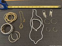 All jewellery items laid out with measuring tape for scale