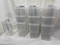 Nine clear containers stacked showing lids and uniform size