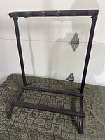 Full view of black metal 5-guitar rack showing frame and padded bars