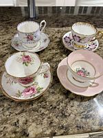Four teacup and saucer sets displayed