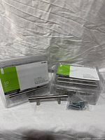 Two retail 10-packs of cabinet pulls, one pull and screws displayed
