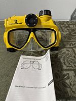 Front view of yellow Liquid Image camera mask and manual