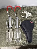 Overall lot showing two bike hooks, two tire trays, white clamp, black gel seat cover
