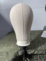 Canvas wig head mounted on clamp stand