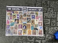 Front view of sealed Whitman stamp set displaying sample stamps and title "100 Different Famous Paintings on Stamps"