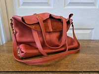 Full view of satchel showing color, shape, handles and strap