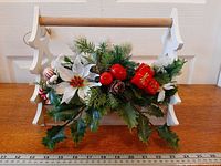 Front view of wooden carrier with artificial Christmas arrangement