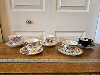 Group shot of all five teacup and saucer sets lined on table
